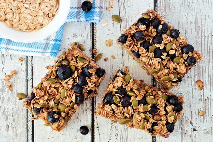 Superfood breakfast bars, overhead on white wood