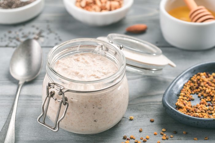 Overnight oats in jar and ingredients on gray wooden table